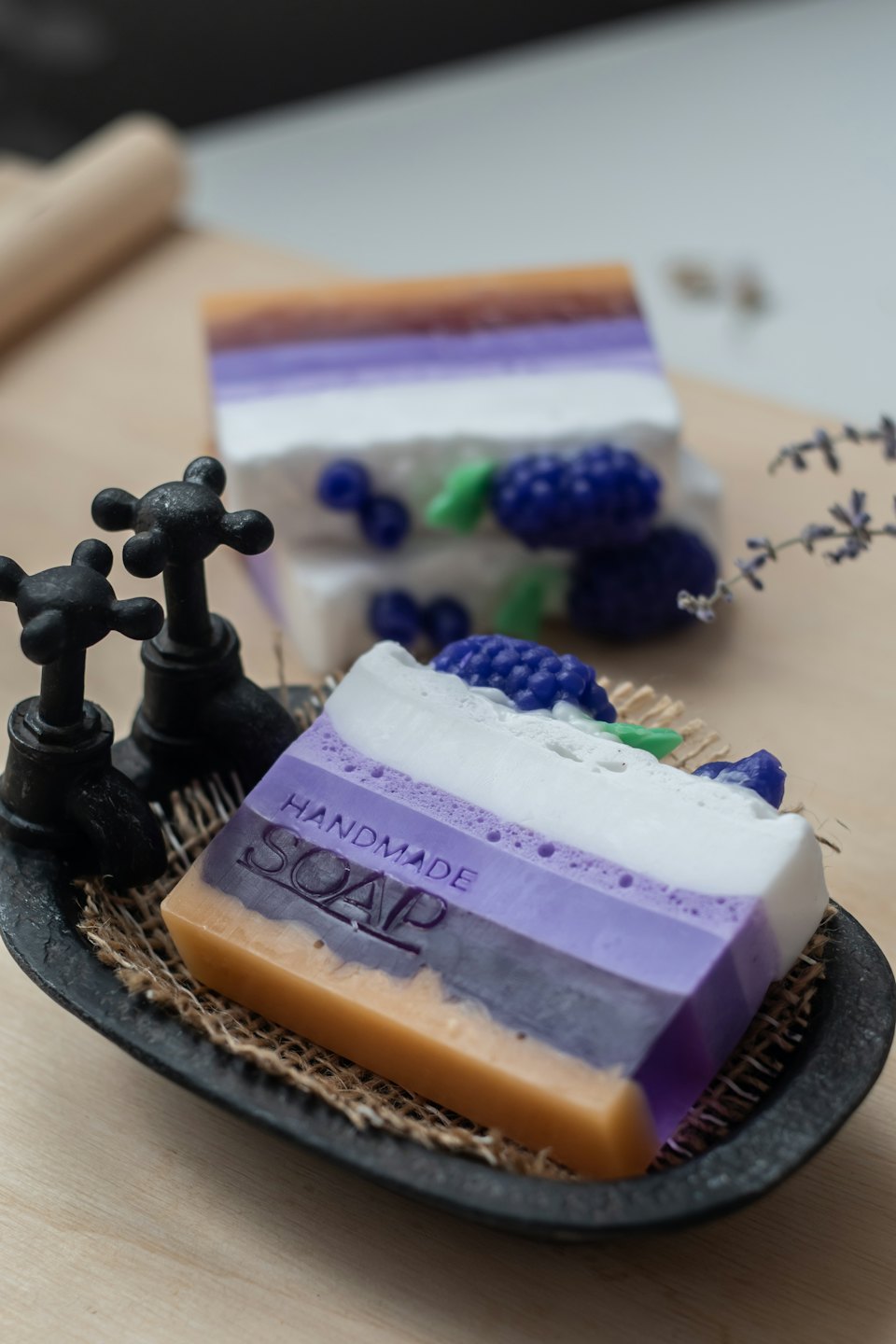 Handmade lavender soap bars resemble desserts on a rustic dish.